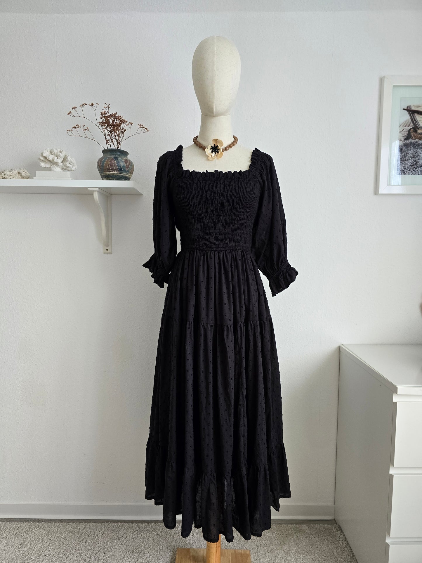 Schwarzes Midi-Kleid aus Baumwolle mit Puffärmeln und Smok-Oberteil für mühelosen, femininen Stil.