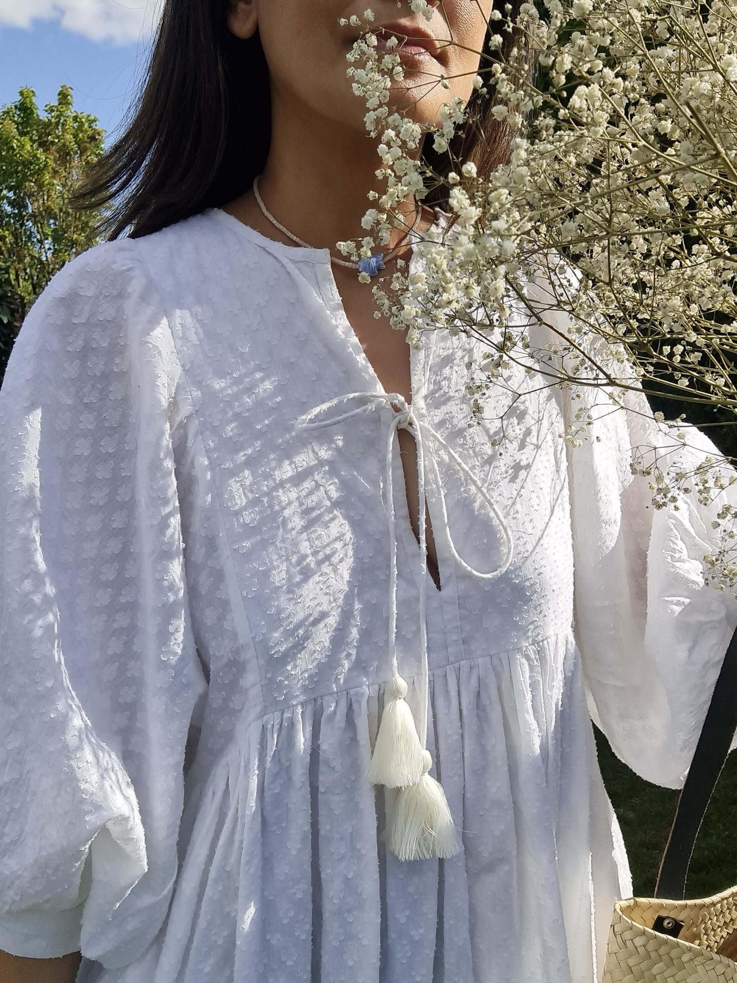 Lucia Weißes Midikleid mit Blumen und einer Person in der Natur, lässig und bequem für den Alltag.