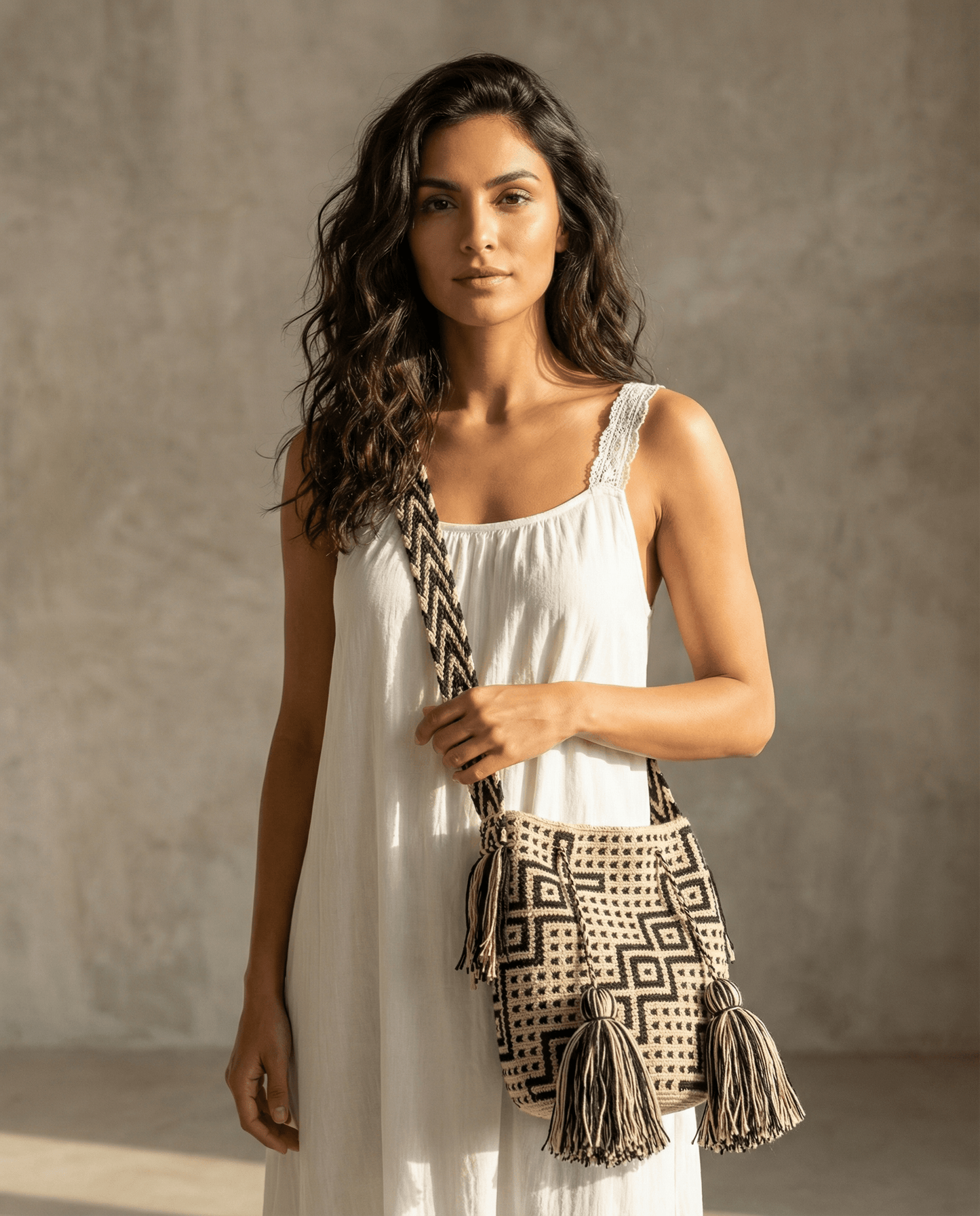 Wayuu Tasche mit Strasssteinen – Creme/Schwarz, handgefertigte Slow Fashion, gezeigt von model in weißem Kleid.