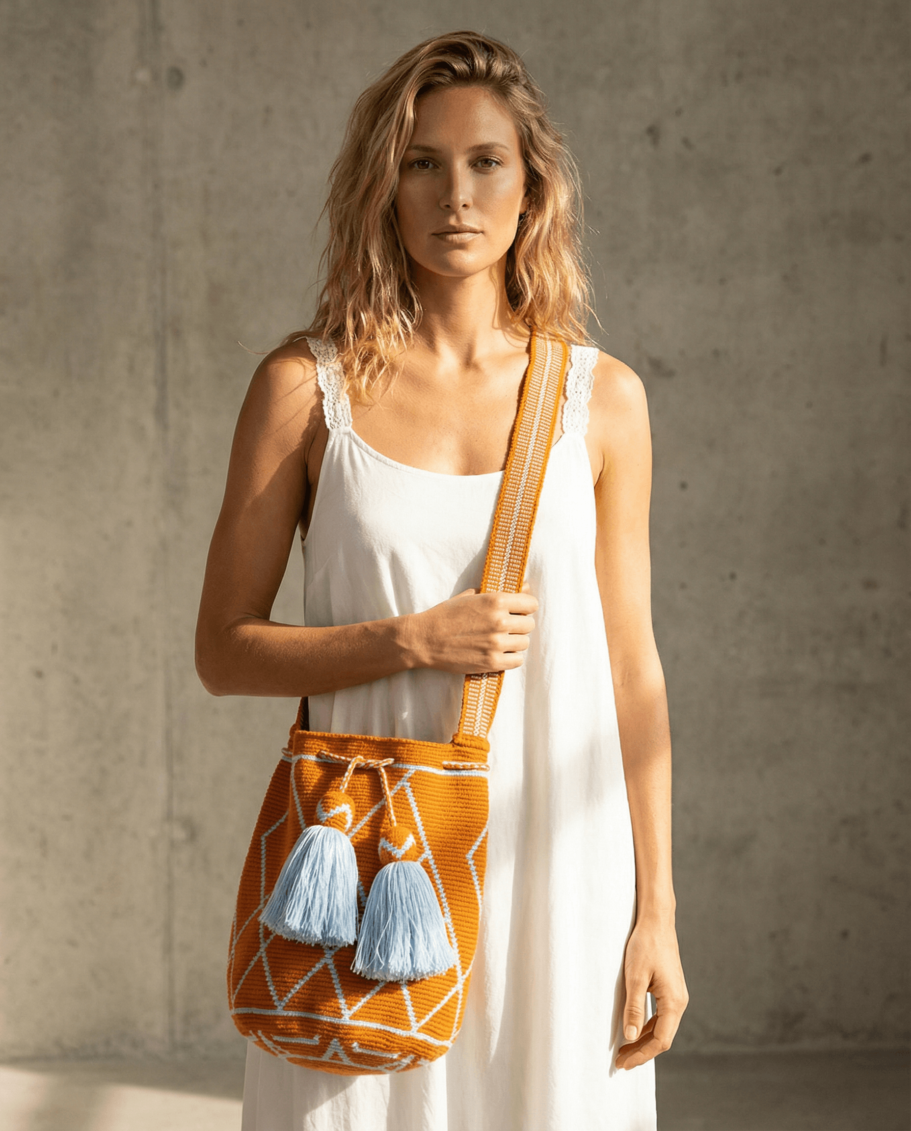 Wayuu Tasche Nr. 19 – Orange/Himmelblau, handgefertigt, präsentiert von Model vor neutralem Hintergrund.