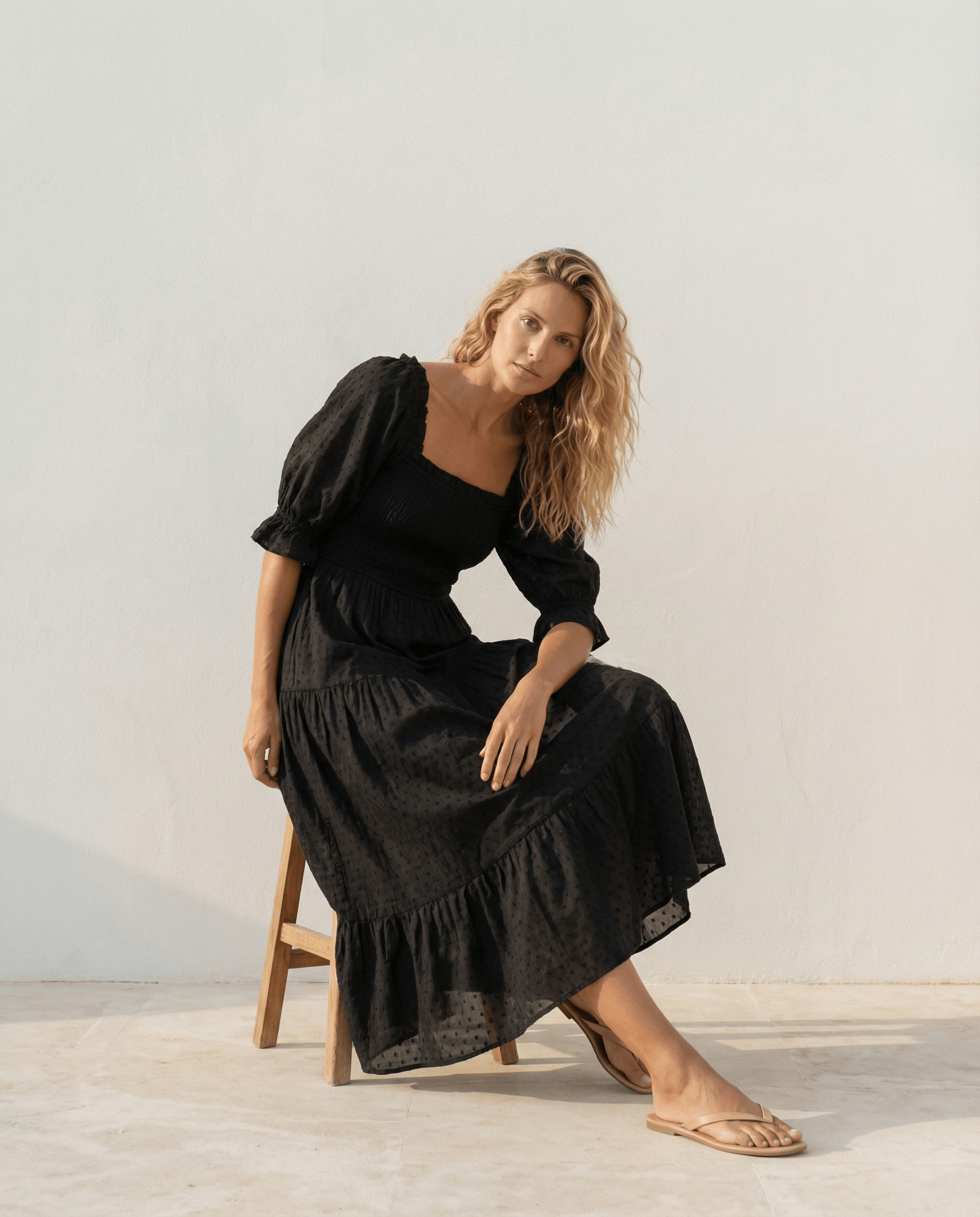 Schwarzes schulterfreies Kleid mit Smokdetails
