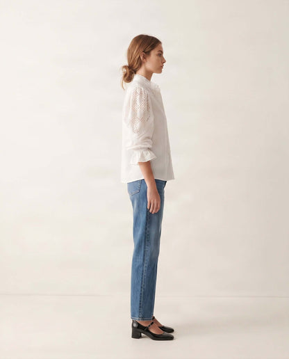 Elegante weiße Damenbluse aus Baumwolle mit dekorativen Spitzendetails und femininem Design.