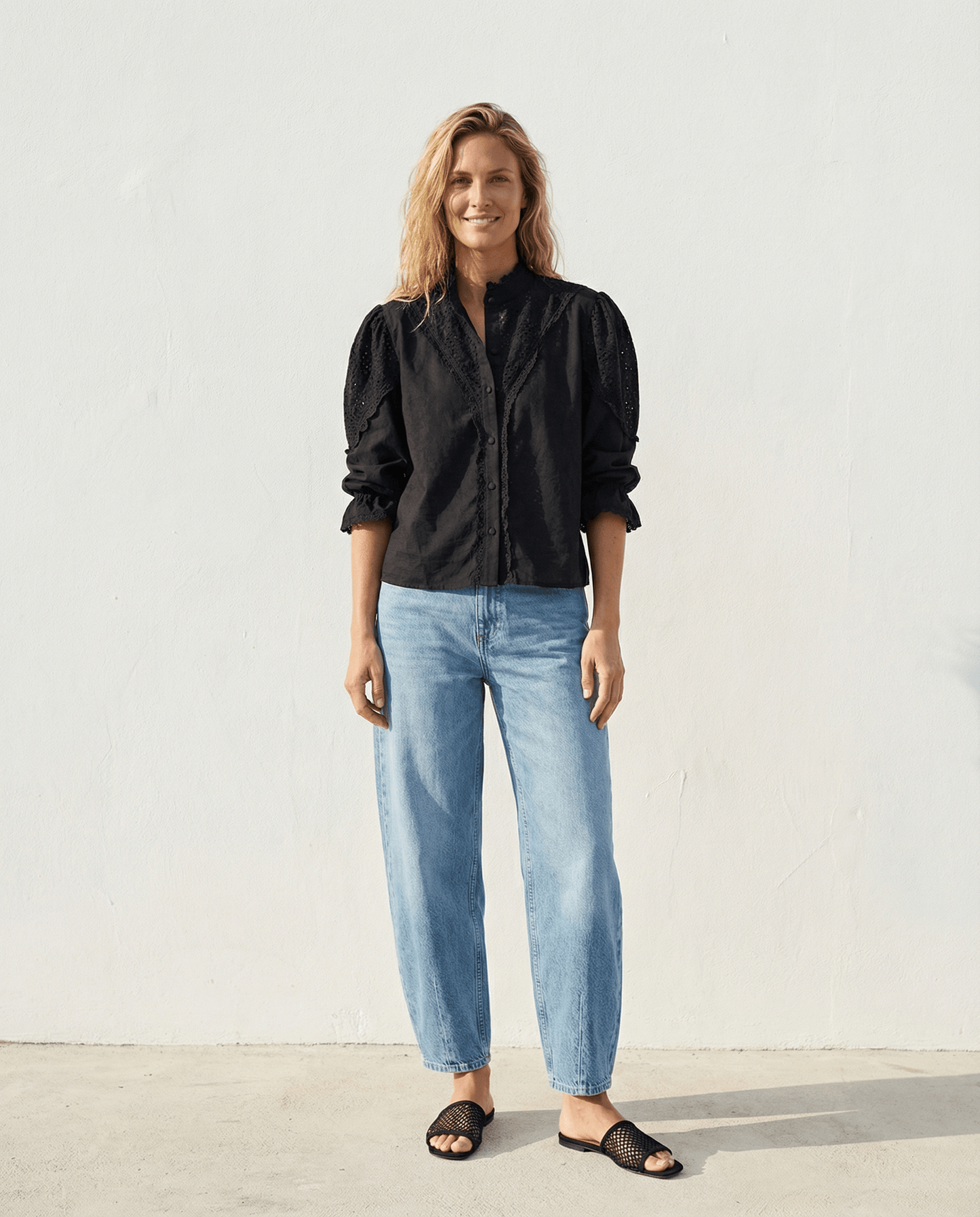 Die Zoey Baumwollbluse - Schwarz in Kombination mit lässigen Jeans, für einen eleganten, handgefertigten Look in Slow Fashion.