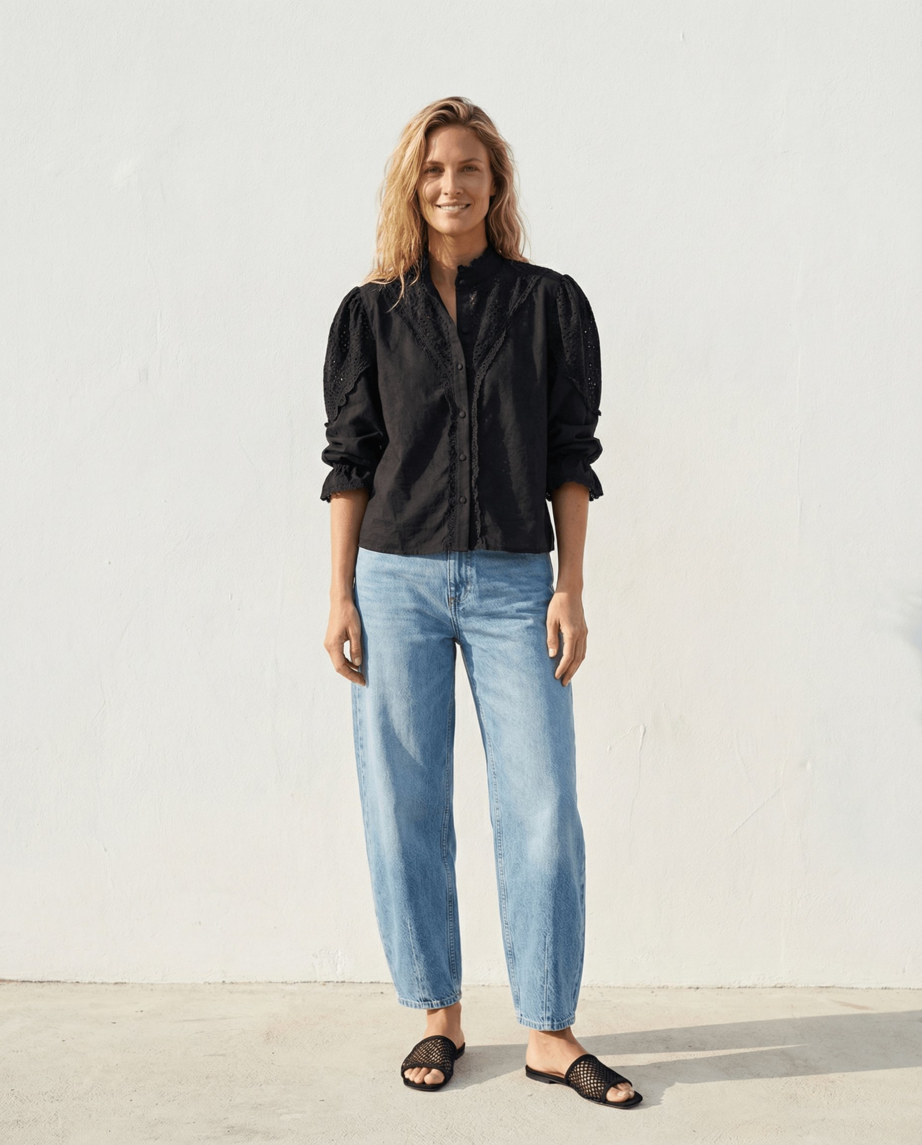 Die Zoey Baumwollbluse - Schwarz in Kombination mit lässigen Jeans, für einen eleganten, handgefertigten Look in Slow Fashion.